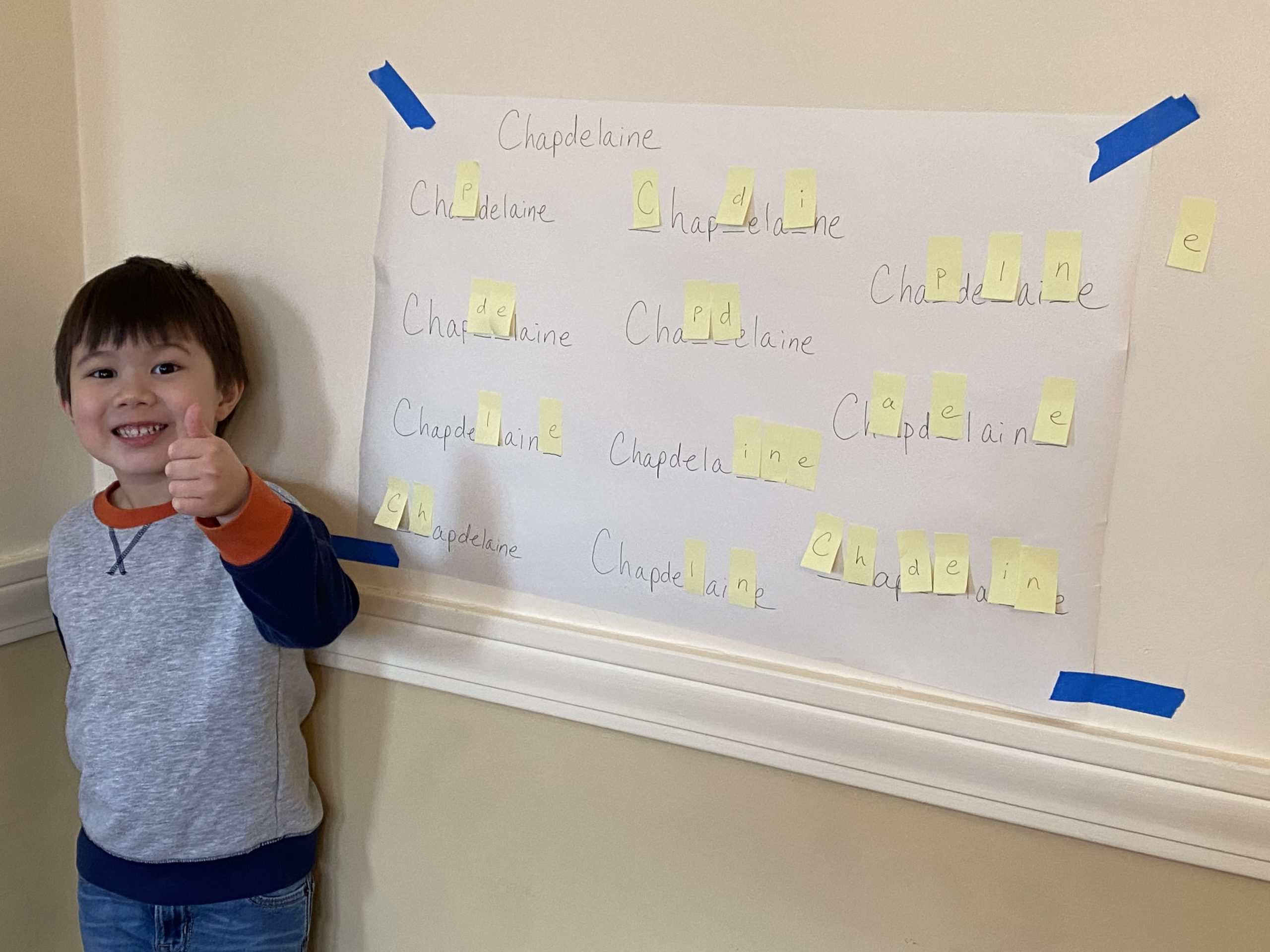 Proud student in front of spelling board