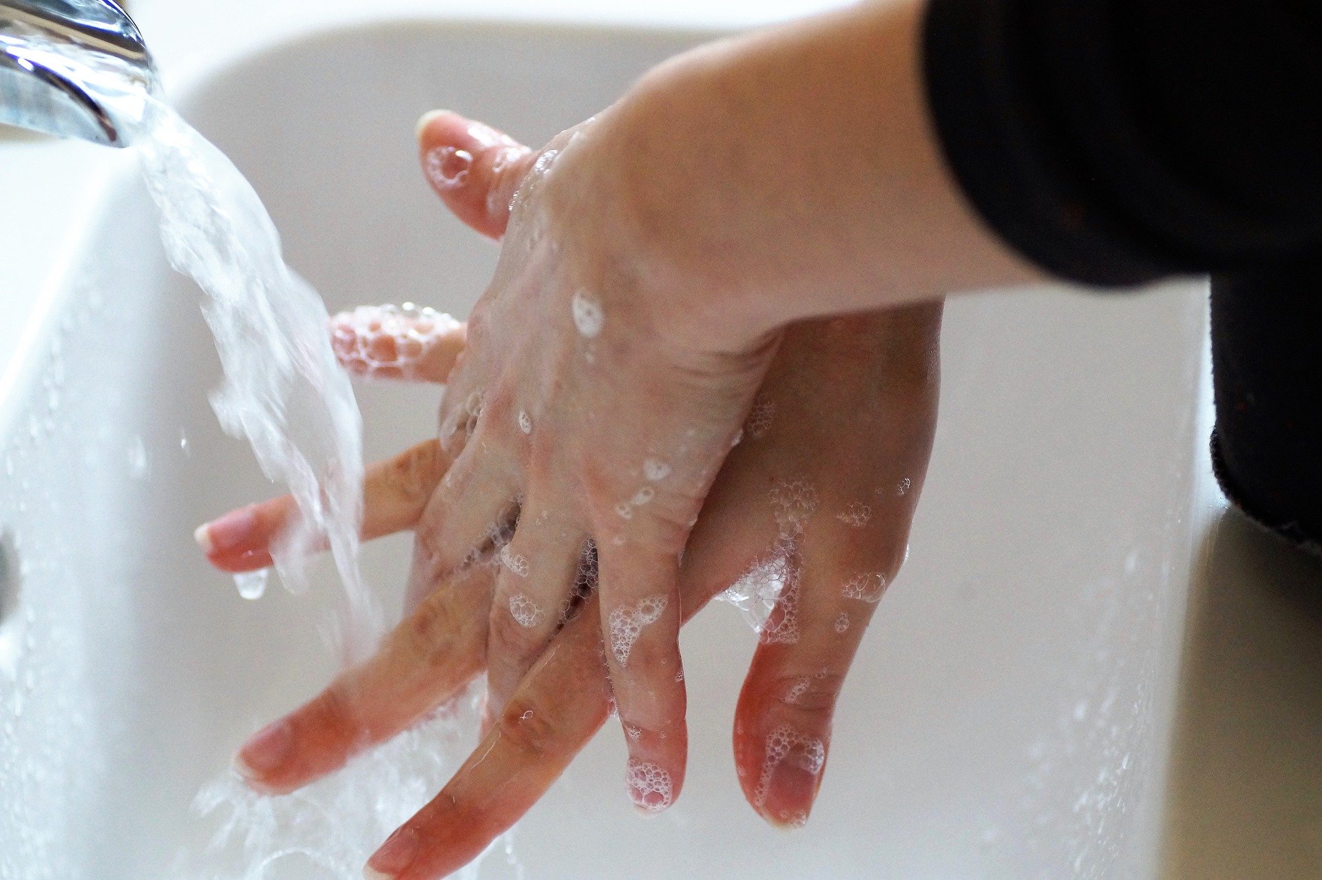 Person washing hands with soap and water