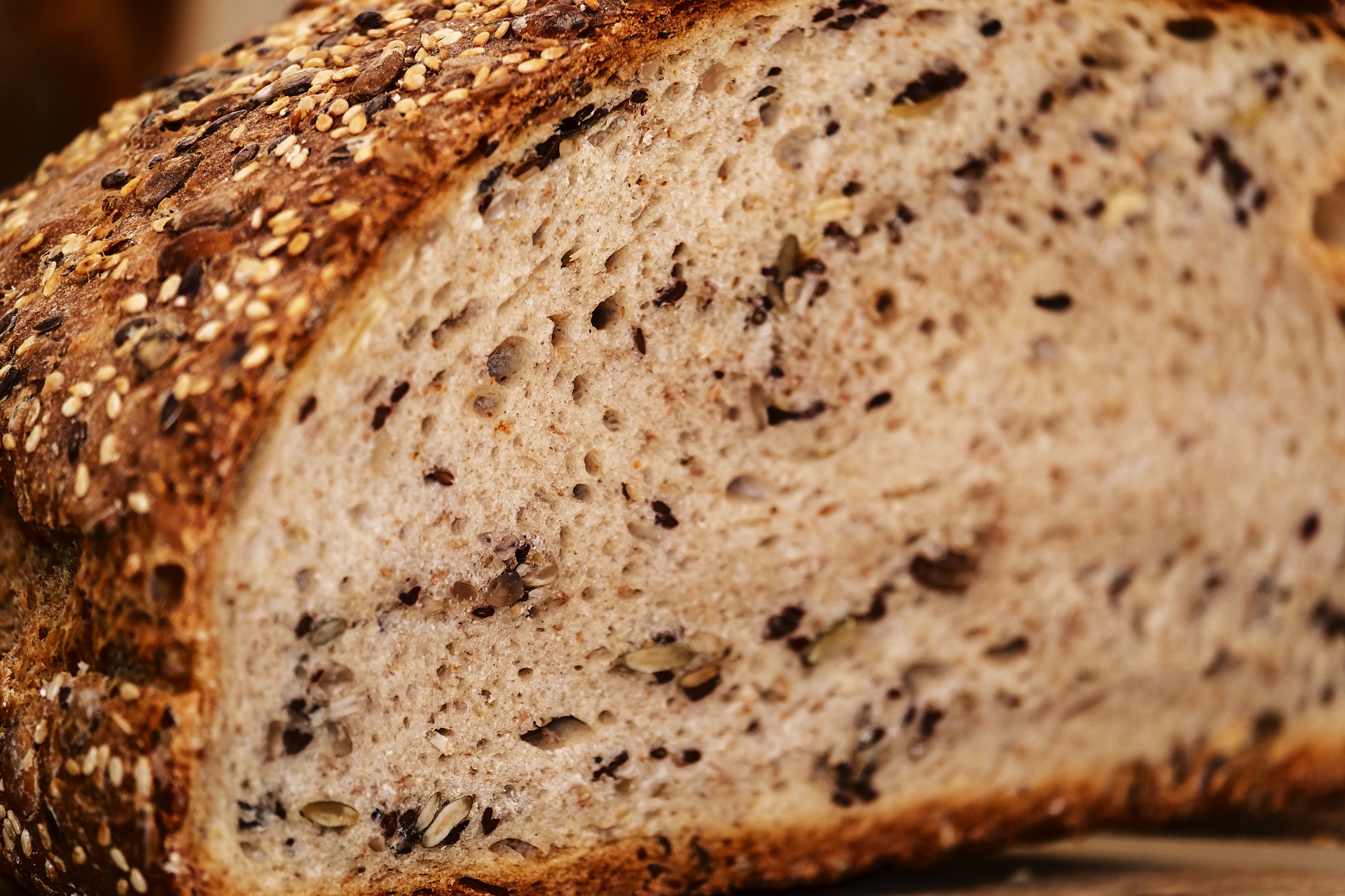 A close-up of a sliced loaf of seeded bread