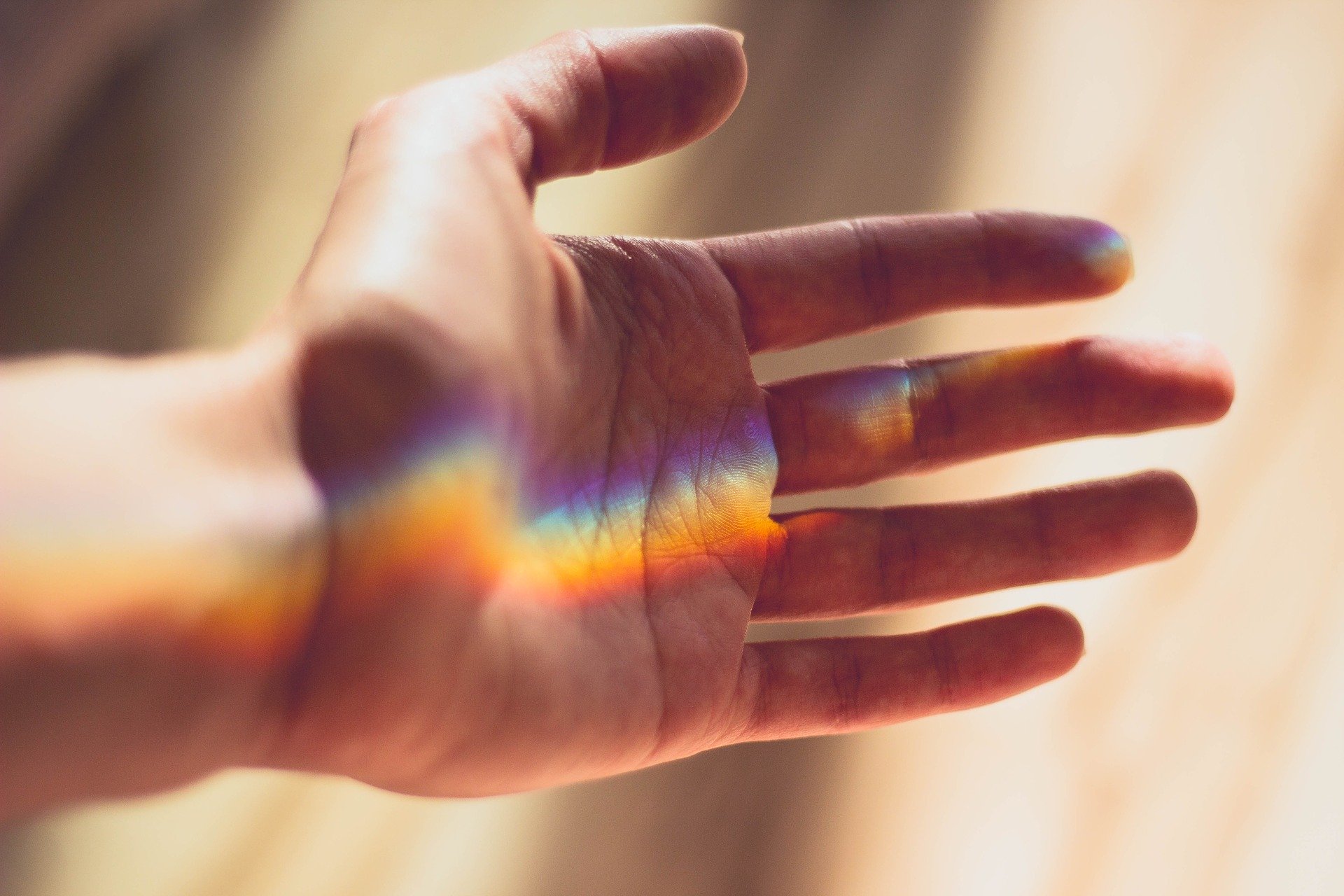 A person's hand with a rainbow on the palm